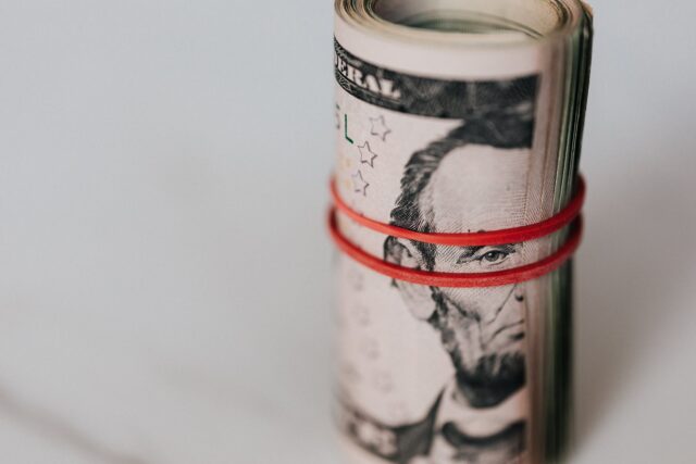 roll of american dollars tightened with red band