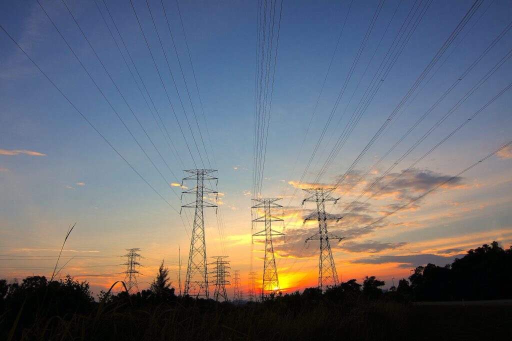 three black metal electricity posts during golden hour