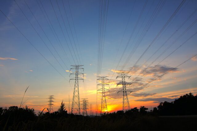 three black metal electricity posts during golden hour